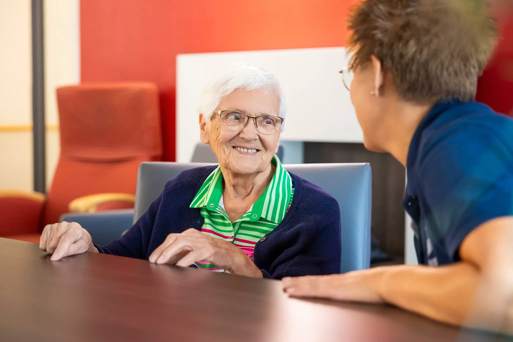 Herzlicher Umgang miteinander ist bei der Alerds-Stiftung eine Basis für ein besseres Leben im Alter. Seniorin und Mitarbeitende in fröhlichem Gespräch